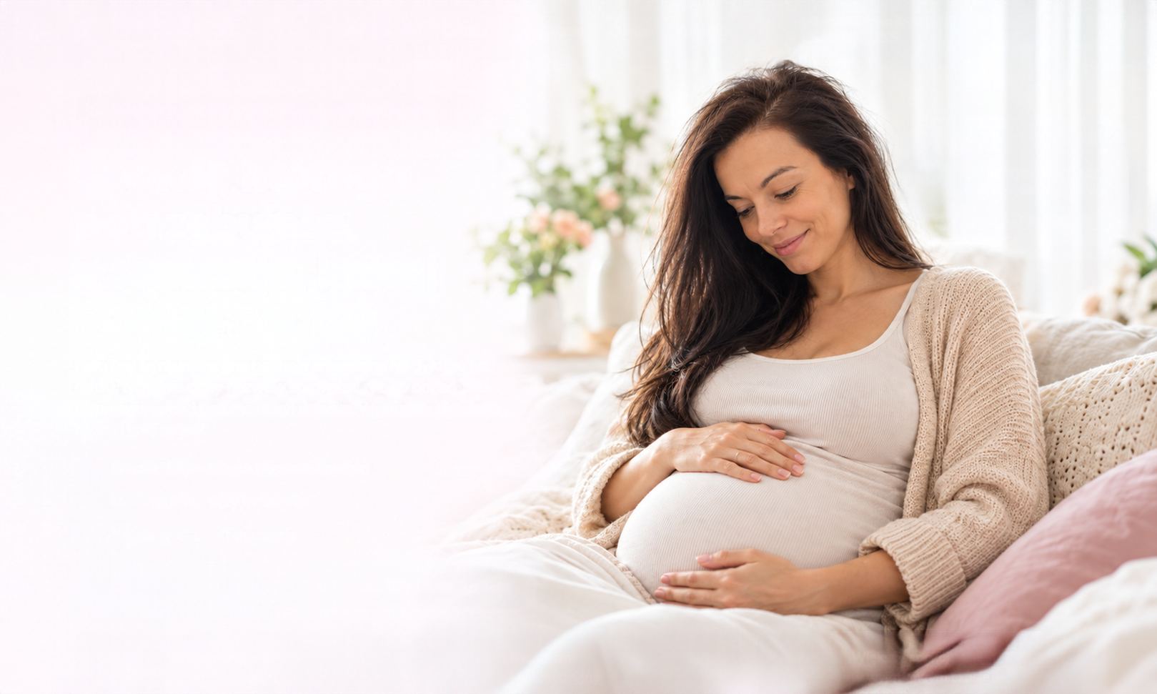 Uśmiechnięta kobieta w ciąży obejmuje brzuch